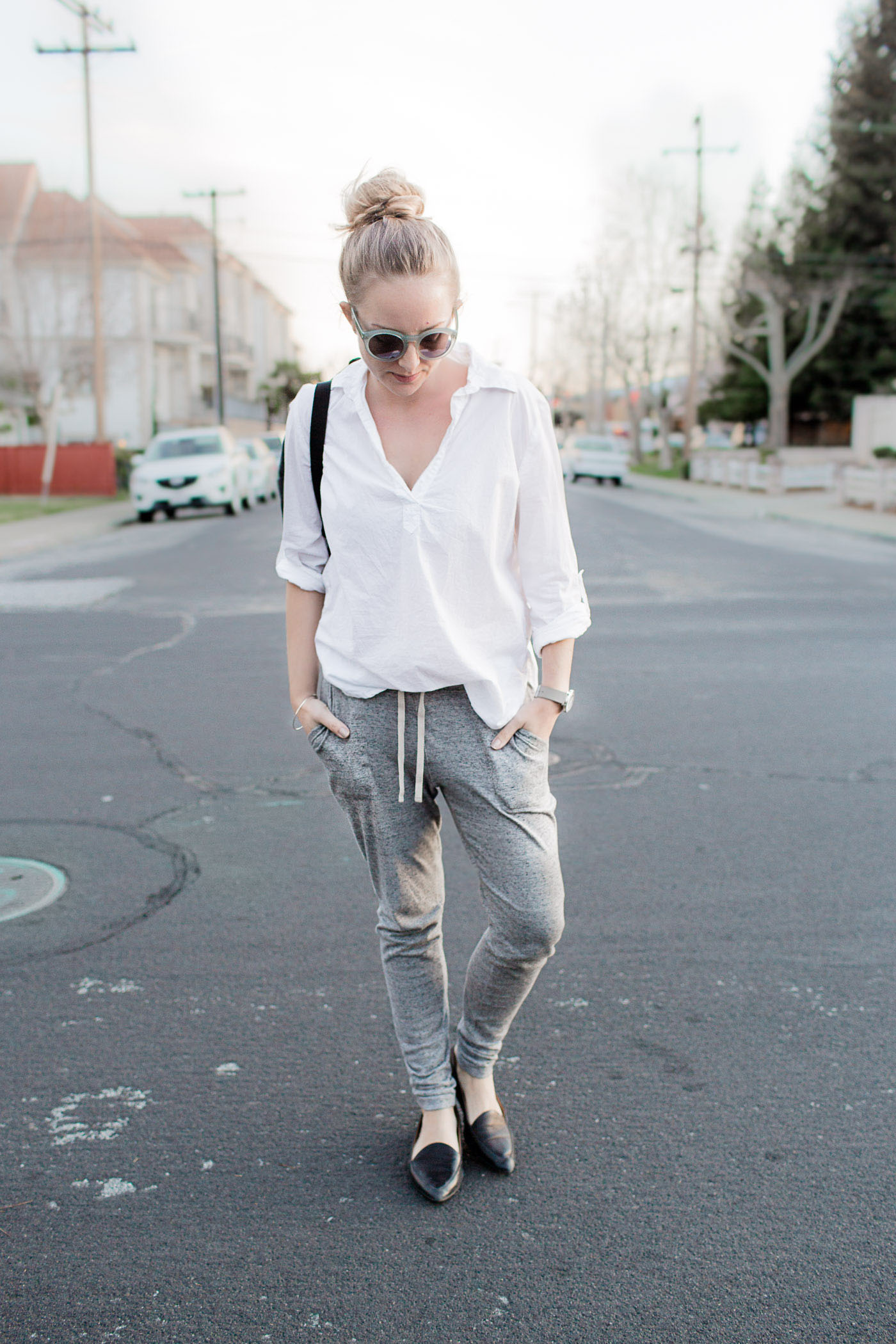 An athleisure outfit featuring relaxed joggers, a backpack, and everlane modern point flats.